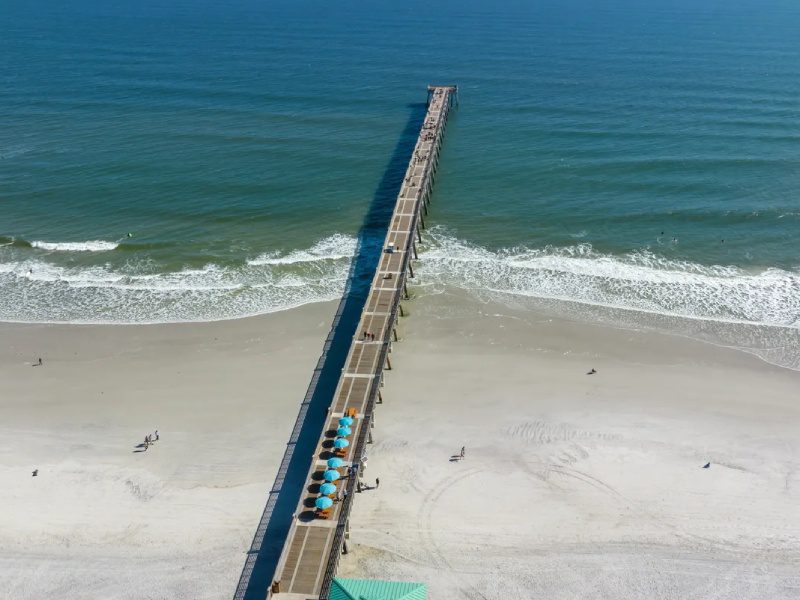 An aerial view of a pier on the beach.